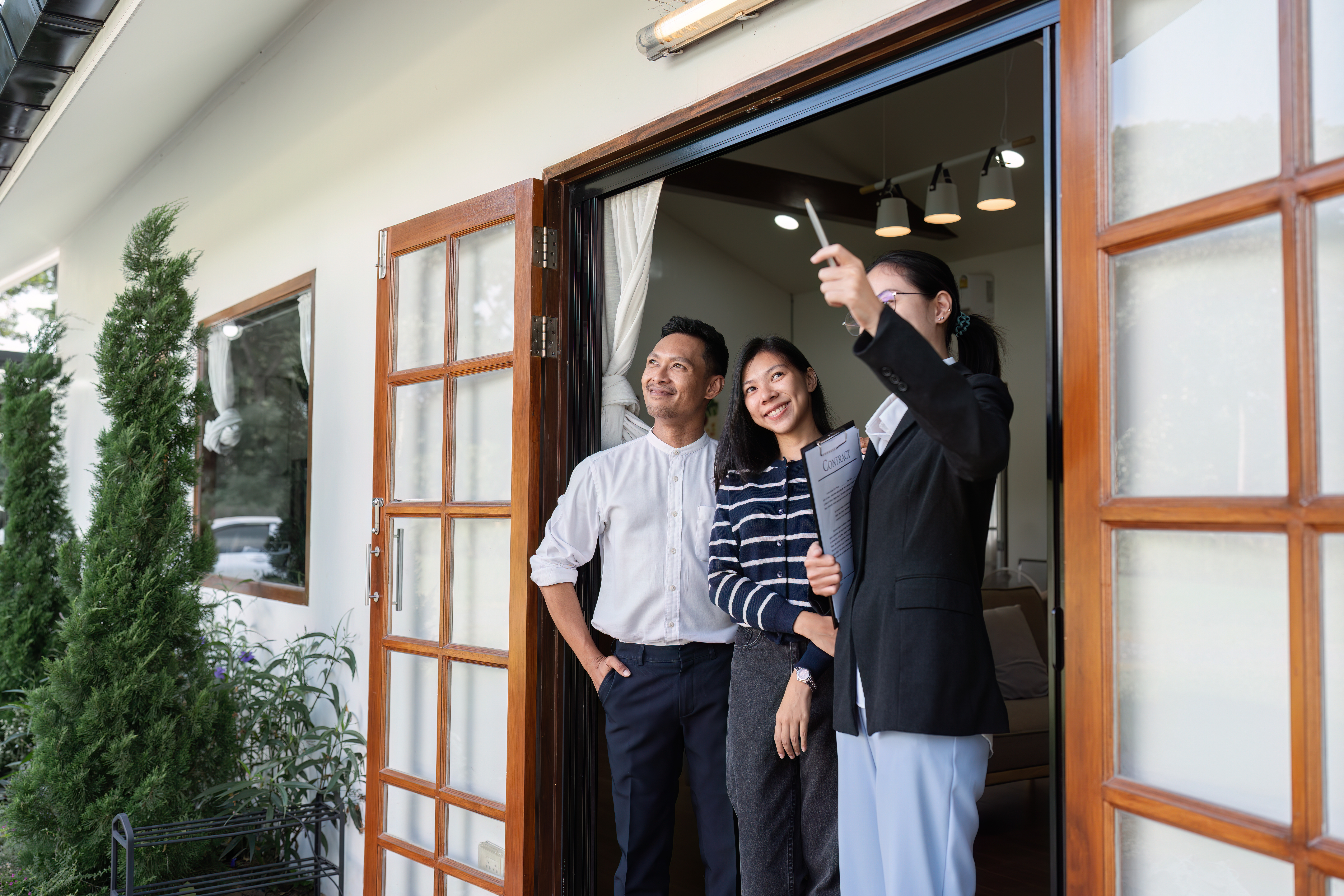 Three people outside a home, representing the discussion of 